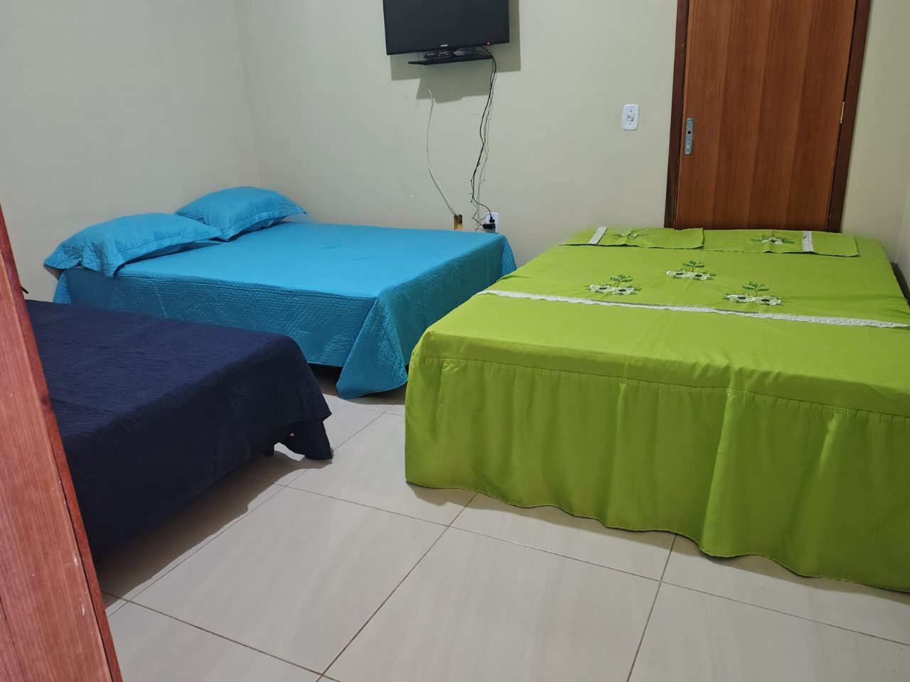 Suíte ampla com três camas e TV
